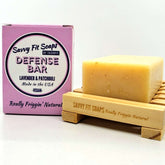 A box of Savvy Fit Soaps Defense Bar in Lavender Patchouli with an open soap, highlighting its plant-based, USA-made, and calming skincare formula.